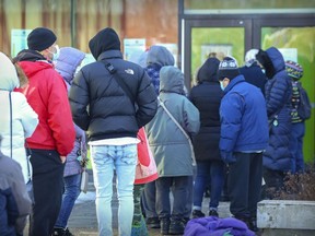 People line up for vaccinations at the Gerry-Robertson Centre in the Pierrefonds on Tuesday. “There’s no way we can vaccinate ourselves out of this current explosion of Omicron,” says Matthew Oughton, an infectious diseases specialist at the Jewish General Hospital.