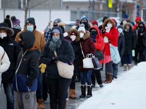 People queue to pick up coronavirus disease (COVID-19) antigen test kits, as the latest Omicron variant emerges as a threat, in Ottawa, Ontario, Canada December 21, 2021. REUTERS/Blair Gable