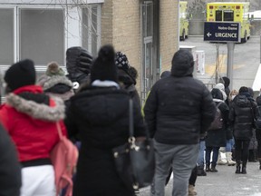 People wait in line on Plessis St. for admittance to the COVID testing clinic at the Notre-Dame Hospital Dec. 22, 2021.