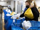 MONTREAL, QUE.  : December 22, 2021 - Volunteer Nancy Saltarelli packs food baskets at the Sun Youth Organization on Wednesday.  Saltarelli has two sons who also volunteered to assemble the baskets.