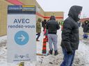 Menschen warten vor dem COVID-19-Testzentrum in Montreal Nord in einer Schlange.