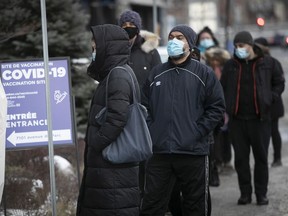 People wait in line at a COVID-19 vaccination clinic on Parc Ave. Dec. 29, 2021.