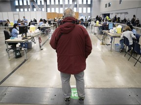 A man waits in line at the COVID vaccination clinic at the Palais des Congres Dec. 30, 2021.