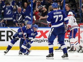 Lightning's Corey Perry is congratulated by Steven Stamkos and Victor Hedman  after scoring the tying goal with 20 seconds left in regulation Tuesday night in Tampa.