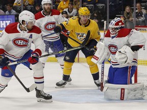 Predators' Mikael Granlund (64) watches as Canadiens goalie Jake Allen blocks a shot with his mask during the first period at Bridgestone Arena on Saturday, Dec. 4, 2021, in Nashville.