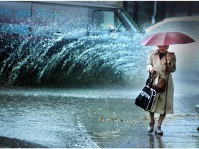 Woman walks in the rain near a fountain