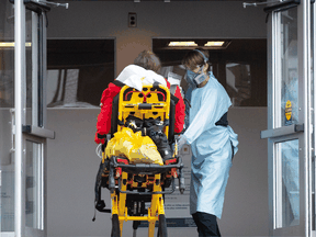 A patient is taken into a hospital by a paramedic in Montreal on Dec. 29, 2021.