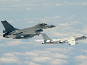 This file handout photo taken and released on May 11, 2018, by Taiwan's Defence Ministry shows a Republic of China (Taiwan) Air Force F-16 fighter aircraft flying alongside a Chinese People's Liberation Army Air Force (PLAAF) H-6K bomber that reportedly flew over the Bashi Channel, south of Taiwan, and over the Miyako Strait, near Japan's Okinawa Island, in a drill. Chinese warplanes made 159 incursions into Taiwan's air defence zone in November according to AFP's database on Dec. 1, 2021, the second-highest month on record as Beijing continues to pile military pressure on the democratic island.