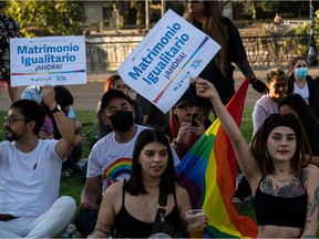 People wait for the passing of a bill to legalize same-sex marriage in Chile with signs reading "Same-sex marriage now," in Santiago, on Dec. 7, 2021.
