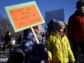 Grade 3 students Zoe Meldrum, 9, left, and Lola Jo Advokaat, 8, right, whose teacher Fatemeh Anvari was removed from her position because she wears a hijab, participate in a rally against Bill 21, in Chelsea, Que., on Tuesday, Dec. 14, 2021.
