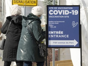 People enter a COVID-19 vaccination site Wednesday, Dec. 1, 2021  in Montreal.