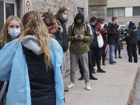 People line up at a COVID-19 test clinic in Montreal on Wednesday. Dr. Mylène Drouin said 95 cases of the new Omicron variant have been detected in in the city, with many more expected int he coming days.