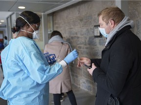 A nurse hands out a swab for a COVID-19 rapid self test at a test clinic in Montreal, on Wednesday, December 15, 2021.