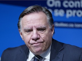 Quebec Premier François Legault listens to a question during a news conference in Montreal on Thursday, Dec.16, 2021.