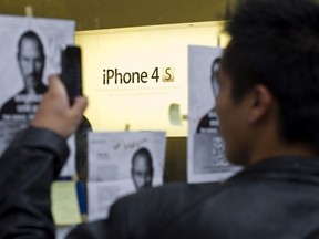 A man takes a photo of a Steve Jobs tribute on the day of the launch of the iPhone 4s at the Apple store in downtown Montreal on Friday, October 14, 2011. "Every young person today has in the palm of their hand a window into the North American zeitgeist," Robert Libman writes.