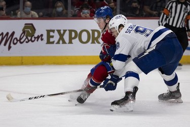 Tampa Bay Lightning defenseman Mikhail Sergachev (98) leans on Montreal Canadiens right wing Cole Caufield (22), successfully dragging him off the play during first period in Montreal, on Tuesday, Dec. 7, 2021.