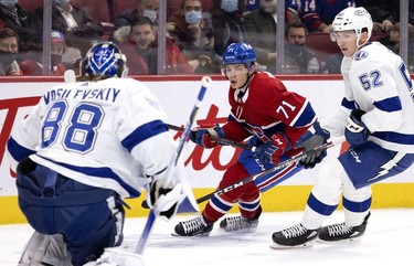 Montreal Canadiens centre Jake Evans (71) tries to get a shot off against Tampa Bay Lightning goaltender Andrei Vasilevskiy (88) as Tampa Bay Lightning defenseman Cal Foote (52) pressures him during first period in Montreal, on Tuesday, Dec. 7, 2021.