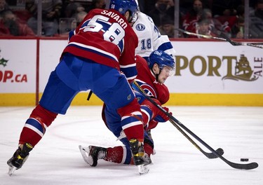 Montreal Canadiens left wing Artturi Lehkonen (62) hits the ice after being hit by Tampa Bay Lightning left wing Ondrej Palat (18) as Montreal Canadiens defenseman David Savard (58) tries to move the puck up the rink during second period in Montreal on Tuesday, Dec. 7, 2021.