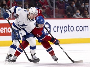 Montreal Canadiens centre Jake Evans (71) and Tampa Bay Lightning left wing Ross Colton (79) struggle to recover the puck during third period in Montreal, on Tuesday, Dec. 7, 2021.