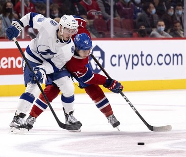 Montreal Canadiens centre Jake Evans (71) and Tampa Bay Lightning left wing Ross Colton (79) struggle to recover the puck during third period in Montreal, on Tuesday, Dec. 7, 2021.