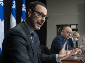 Quebec Education Minister Jean-François Roberge, announces a training program for health workers, at the legislature in Quebec City, Wednesday, Dec. 1, 2021. Quebec Health Minister Christian Dubé, right, looks on.