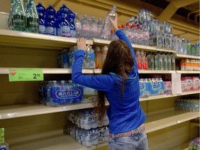 A woman reaches for bottled water at a Montreal grocery store after a past boil water advisory. As is often the case, last weekend's advisory in the West Island saw many grocery shoppers stocking up, with some stores limiting water purchases.