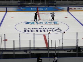 Staff members move a net as they maintain the rink, at an ice hockey competition venue for the 2022 Olympic Winter Games, inside the National Indoor Stadium,  in Beijing, China April 1, 2021. REUTERS/Tingshu Wang/File Photo