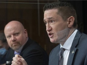 Quebec Minister Responsible for the Fight Against Racism Benoit Charrette  speaks at a news conference on measures to prevent racism on Thursday at the National Assembly. Minister Ian Lafrenière, left, looks on.