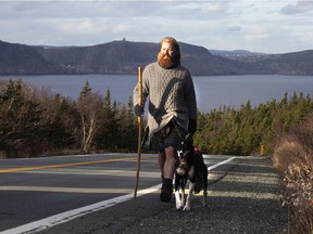 Michael Yellowlees of Scotland and his husky, Luna, walk the road to Cape Spear in Newfoundland and Labrador on Sunday, Dec. 5, 2021. Yellowlees completes his cross Canada journey at the most easterly point in North America.
