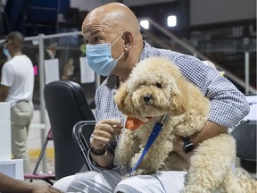 Zootherapist Sylvain Gonthier and Bidule comforted people at a vaccination clinic in Montreal last summer.