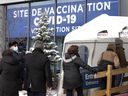 A line forms at the Parc Avenue COVID-19 vaccination site in Montreal, Monday, January 3, 2022.
