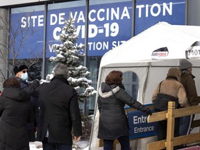 A line forms at the Parc Ave. COVID-19 vaccination site in Montreal, on Monday, January 3, 2022.