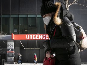 A Montrealer walks past the CHUM emergency department entrance Jan. 11, 2022.