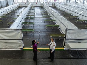 Mayor Valérie Plante and Fire Chief Richard Liebmann chat in front of a new homeless shelter/COVID-19 clinic at the Stade de soccer de Montréal on Papineau Ave. in Montreal on Thursday, Jan. 13, 2022.