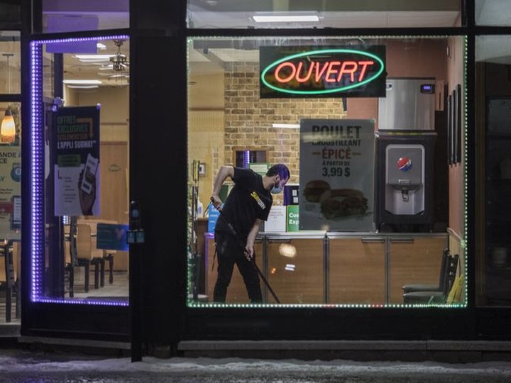  A man mops a floor at a restaurant on Ste.-Catherine St. West after curfew on Friday, January 7, 2022.