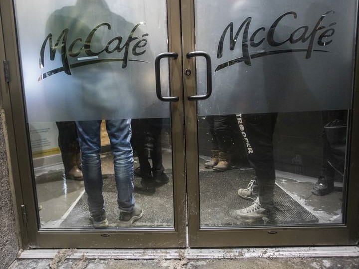  Food deliverers wait for their orders in a cramped enclosure at a McDonald’s restaurant on Ste.-Catherine St. on Friday, January 7, 2022.