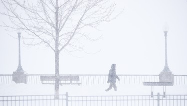 A Montrealer takes a walk in Old Montreal during the first big snowstorm of the new year Jan. 17, 2022.