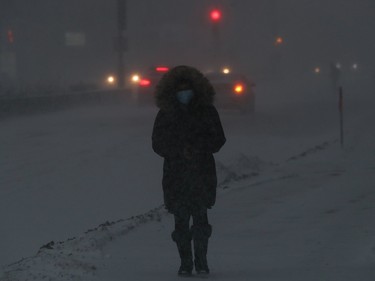 Montrealers negotiate snow and the wind during winter storm on Jean-Talon St. in Montreal Jan. 17, 2021.