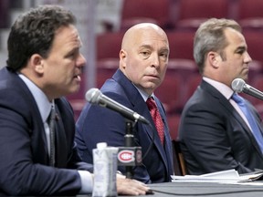 Kent Hughes, centre, listens to Jeff Gorton, the Canadiens' executive vice-president of hockey operations, left, as owner Geoff Molson looks on.