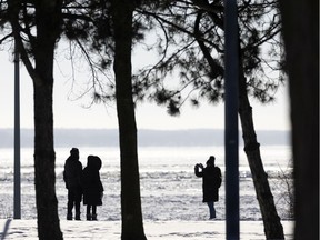 People stop to take pictures as they brave the cold for a walk along the lakeshore in Dorval Jan. 16.