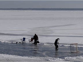 People play hockey on a section of ice on Lac St-Louis as they brave the cold in Pointe-Claire on Sunday.