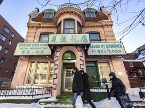 People walk past a house on St-Urbain Street in Montreal's Chinatown on Sunday, Jan. 23, 2022. Parts of Chinatown, including this house, will be classified as a heritage district.