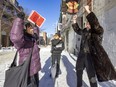 May Chiu, left, and Murielle Chan of Progressive Chinese of Quebec and Chinatown resident and preservation activist Jean-Philippe Riopel celebrate news that parts of Chinatown, including this section of de La Gauchetière St., will be classified as a heritage site.