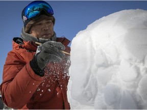 Kirkland artist Shufeng Zhang puts the finishing touches on his newest snow sculpture of a stone lion.