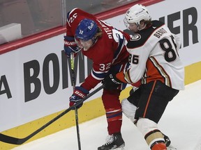 Montreal Canadiens' Rem Pitlick (32) and Anaheim Ducks' Simon Benoit (86) battle for puck during first-period action in Montreal on Thursday, Jan. 27, 2022.