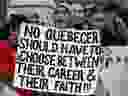 A woman holds a sign at a demonstration to denounce the Quebec government's Bill 21 in Montreal on Sunday, April 7, 2019.