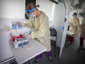 Nurses Diane Delli Colli, left, and Mary-Lou Foley prepare their testing stations at a mobile COVID testing site at Cloverdale Village in the Pierrefonds-Roxboro borough in 2020.