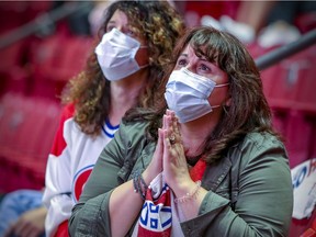 A couple of Montreal Canadiens fans watch their team lose game 2 of the Stanley Cup finals against the Tampa Bay Lightning on the big screen at the Bell Centre in Montreal, Wednesday June 30, 2021.  The Habs and Lightning were playing the game in Tampa, Florida. (John Mahoney / MONTREAL GAZETTE)