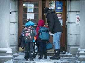 Father Russ Cooper opens door to his kids and others as they go back to school following the Christmas and COVID break at Willingdon School on Tuesday, January 18, 2022.