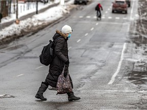 A woman wearing a mask because of the COVID pandemic makes her way along a Montreal street. "One day, we will put the pandemic behind us," Fariha Naqvi-Mohamed write.